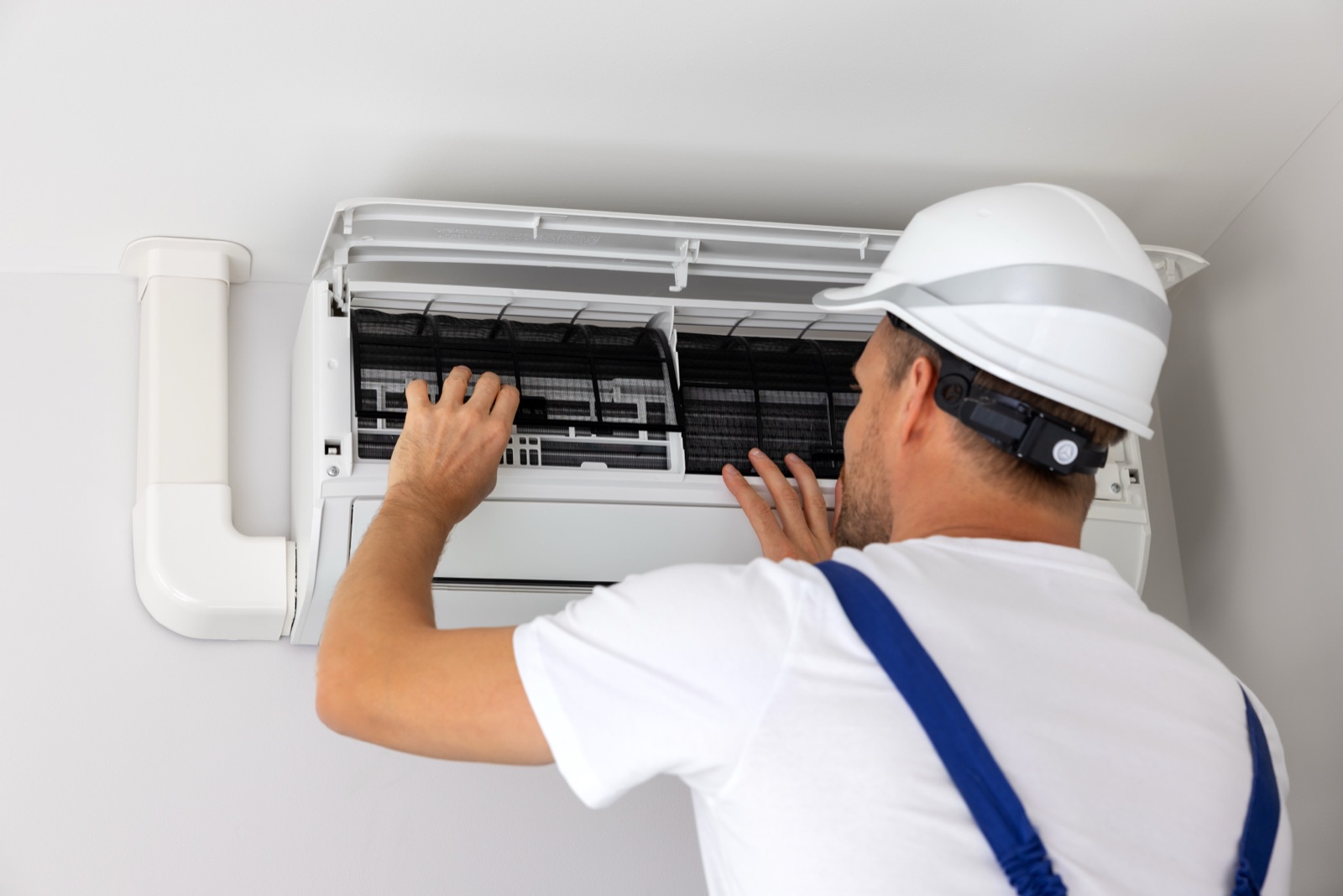 Technician opening a wall-mounted air conditioner